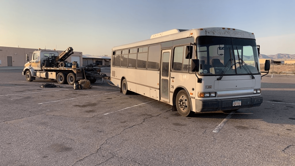 Heavy duty towing equipment staged beside a disabled bus